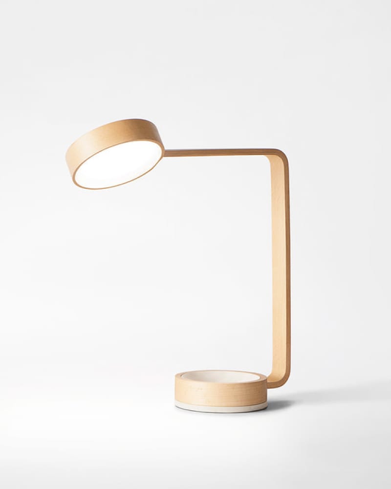 Steam-bent pale wood desk lamp with circular LED head and ceramic base tray