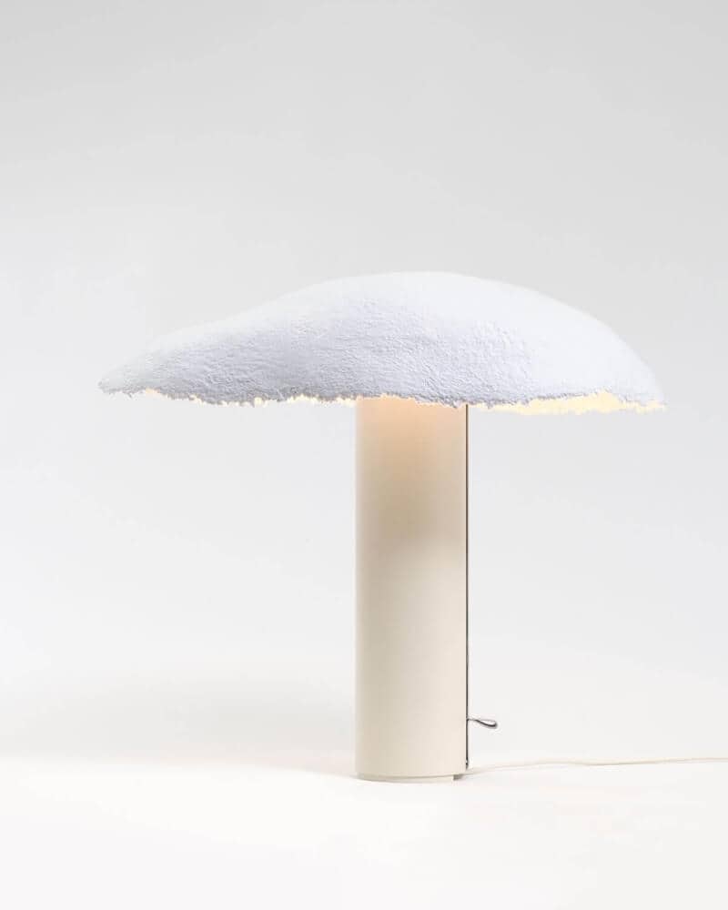Sculptural handmade paper-shade table lamp on a cylindrical cream base